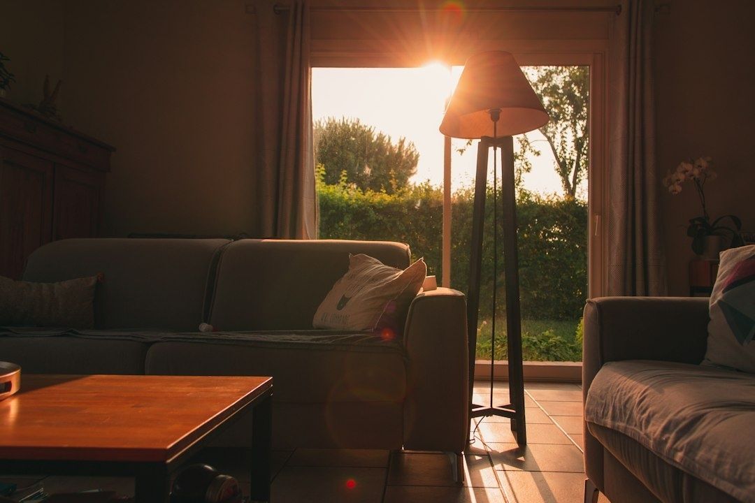 Auringonvalo siivilöityy olohuoneeseen lampun ja sohvien ohi